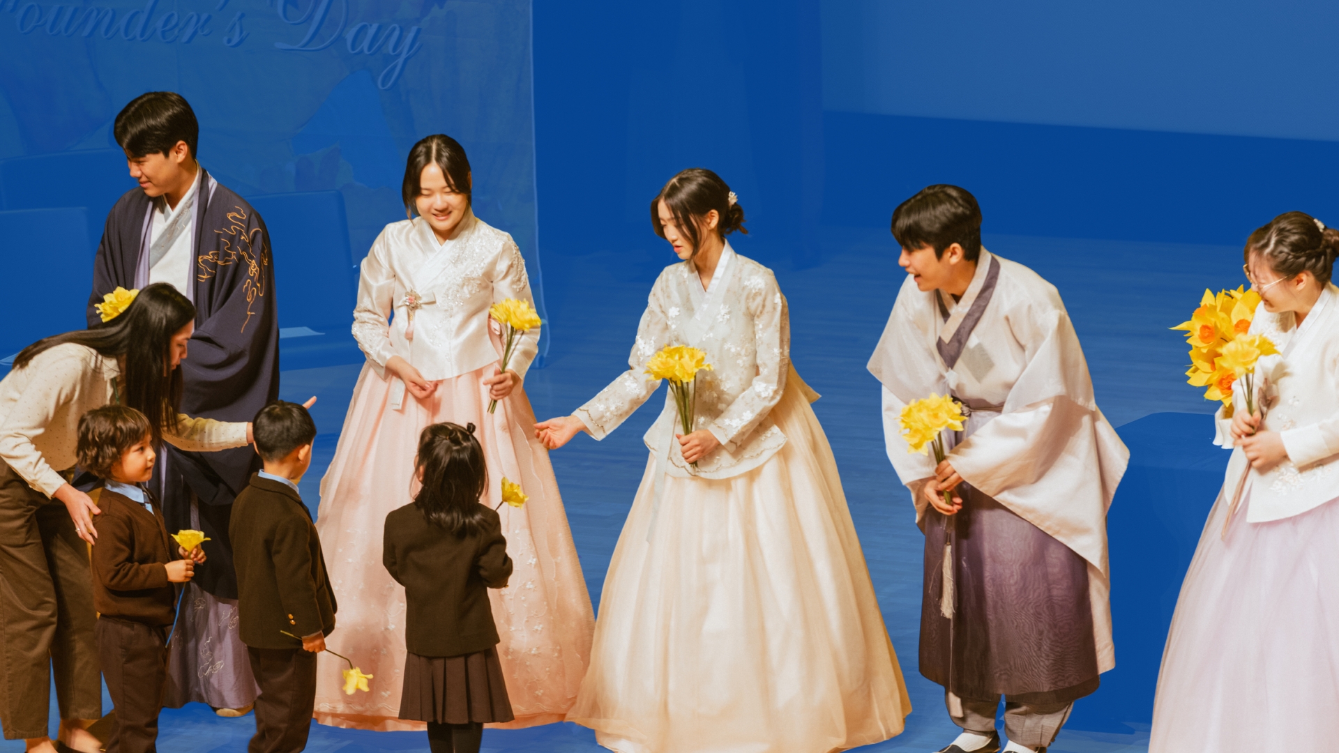 Senior School students from NLCS Jeju gifting Junior School Students Daffodils during the Founder's Day Daffodil procession